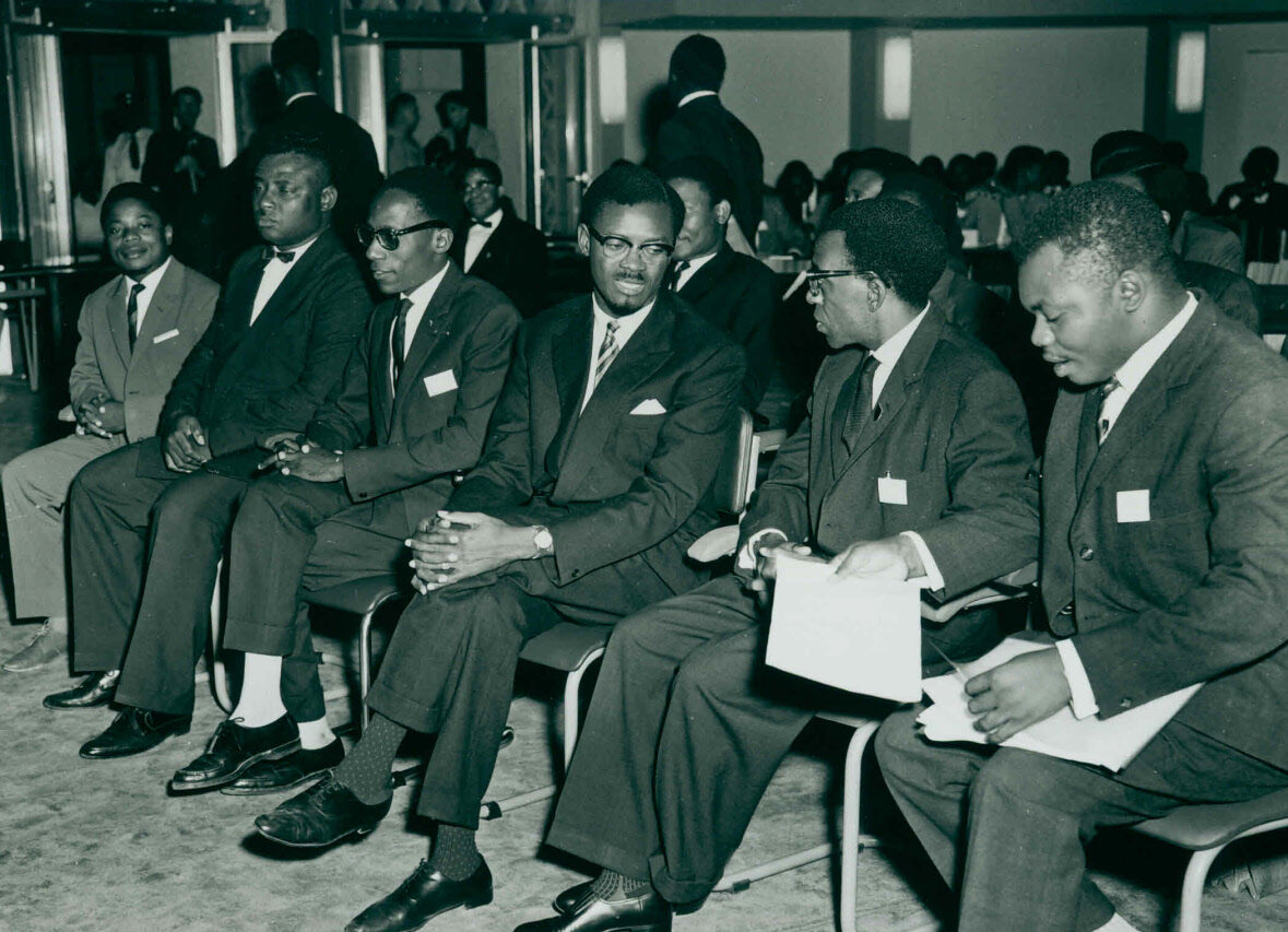 A row of African men dressed if business suits sitting side by side.